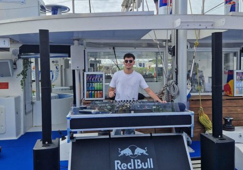Cabina de DJ con equipo de sonido y branding Red Bull en el catamarán Ninah