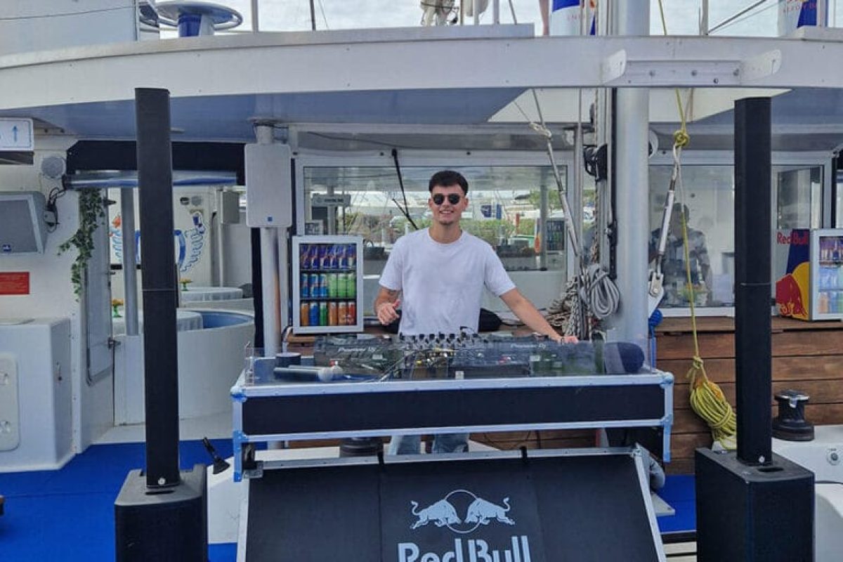 Cabina de DJ con equipo de sonido y branding Red Bull en el catamarán Ninah